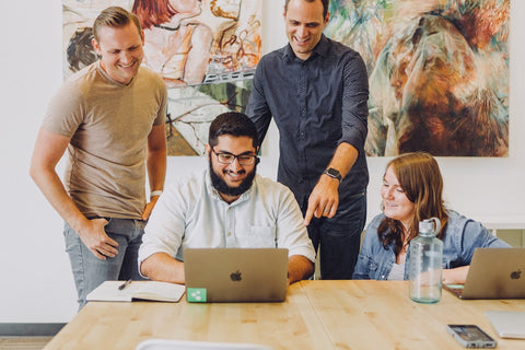 A team reviewing a design on a laptop in a startup office