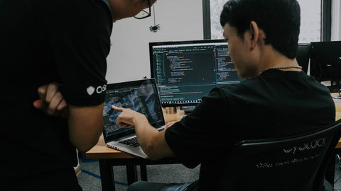 Two developers working together on computers in an office