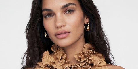 Sif Jakobs model wearing gold hoop earrings, campaign banner from the Shopify storefront